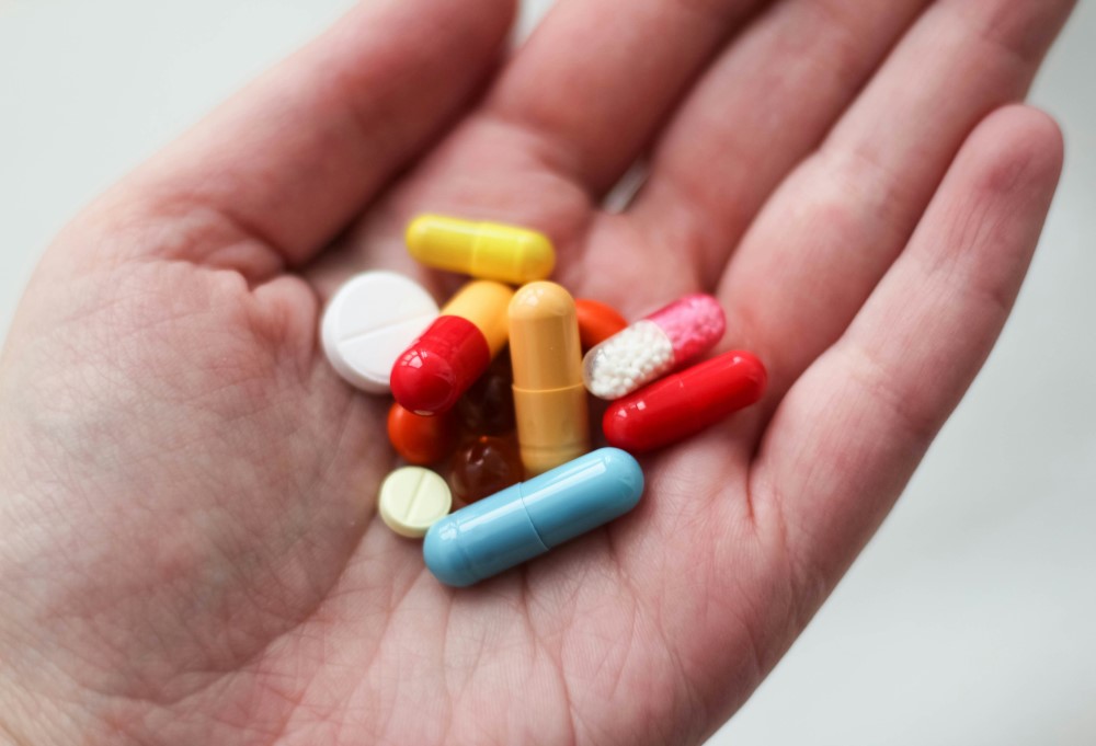 assorted pills in the palm of someone's hand