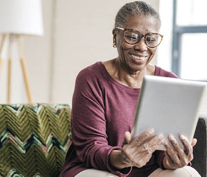 woman on sofa looking at her tablet